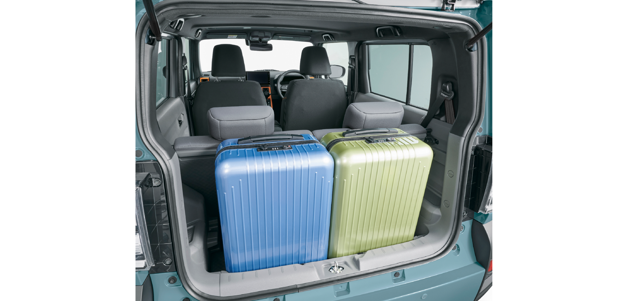 Open SUV trunk with two hard-shell suitcases (blue and lime green) stacked in the cargo area, with rear seats visible and teal exterior.